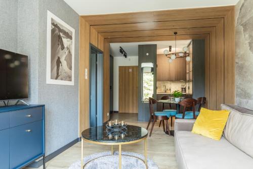 un soggiorno con un divano e un tavolo di Apartament Górski Przystanek a Szklarska Poręba