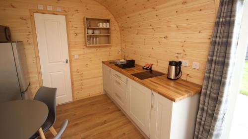 a kitchen in a log cabin with a counter at Barker Stakes Farm in Pickering