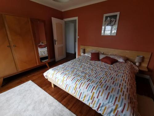 une chambre avec un grand lit aux murs rouges dans l'établissement Ty Mam Goz - Plages à 5 min - wifi - jardin, à Concarneau
