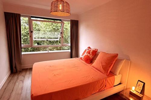 - une chambre avec un lit orange et une fenêtre dans l'établissement Cœur de Confluence, à Lyon