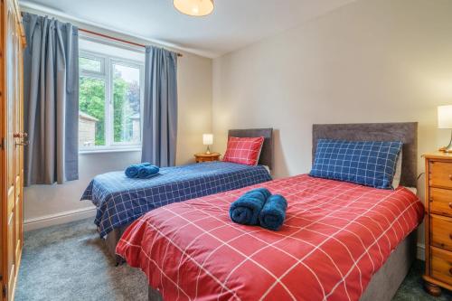 Un dormitorio con dos camas y una ventana. en Shoemakers House, en Kendal