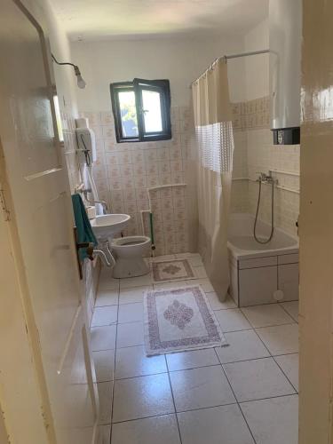a bathroom with a toilet and a tub and a sink at Racina Apartmani in Plav