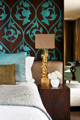 a bedroom with a bed and a table with a lamp at Mandarin Oriental Al Faisaliah, Riyadh in Riyadh