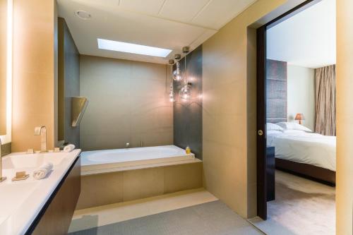 a bathroom with a tub and a sink and a bed at Mandarin Oriental Al Faisaliah, Riyadh in Riyadh