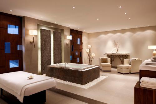 a bathroom with a tub in a room with chairs at Mandarin Oriental Al Faisaliah, Riyadh in Riyadh