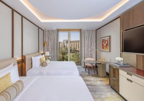 a hotel room with two beds and a flat screen tv at Mandarin Oriental Al Faisaliah, Riyadh in Riyadh