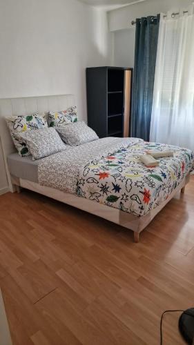 Ce lit se trouve dans une chambre dotée de parquet. dans l'établissement Appartement spacieux à Vaujours, vue sur le jardin, à Vaujours