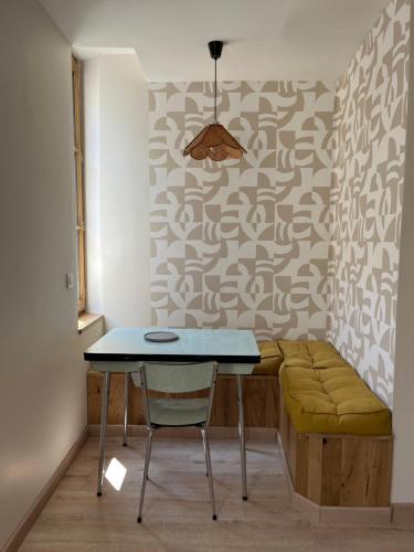 une salle à manger avec une table et un banc dans l'établissement Appartement Champollion 2, à Figeac