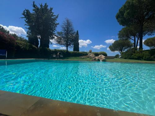 a swimming pool with blue water in a yard at Villa Val delle Vigne in Diaccialone