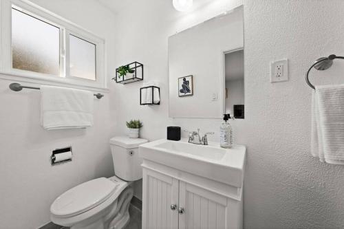 a white bathroom with a toilet and a sink at The Cozy Haven Retreat in Novato
