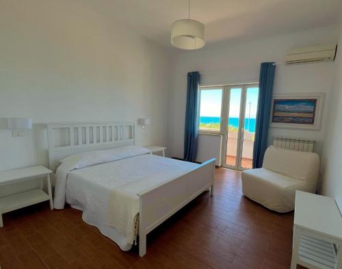 a bedroom with a bed and a chair and a window at LA PERLA BIANCA Apartment - Near Train Station and Best Beaches with Amazing Sunsets in Anzio