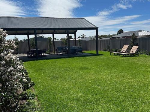 a gazebo with chairs and a picnic table in a yard at The Nagambie Stay in Nagambie
