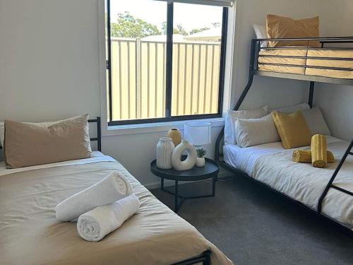 a bedroom with two bunk beds and a table at The Nagambie Stay in Nagambie