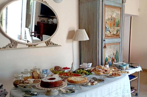 een tafel met eten erop met een spiegel bij Villa Carola in Gallipoli