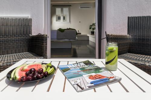 a table with a bowl of fruit and a magazine at Avra Milos in Zefiría