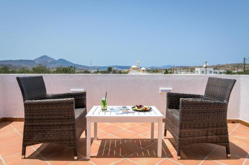 a white table and chairs on a patio with a view at Avra Milos in Zefiría