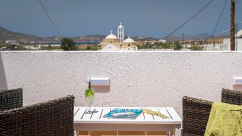 a white table with chairs and a vase on it at Avra Milos in Zefiría