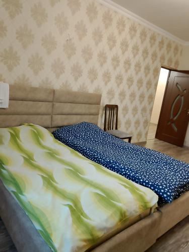 a bed in a bedroom with a bedspread on it at Ksenya B&B in Tatʼev