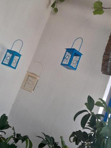 three lights on a wall with a clock on it at Alexandra Studios in Néos Pírgos