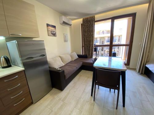 a kitchen and living room with a couch and a table at КАСКАДАС Луксозни нови студия in Sunny Beach