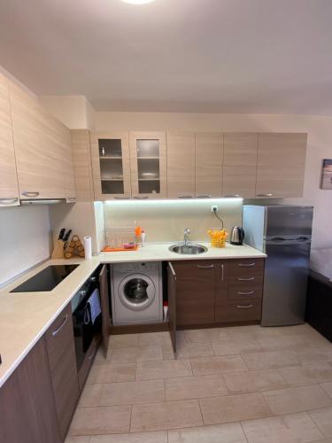 a kitchen with a sink and a washing machine at КАСКАДАС Луксозни нови студия in Sunny Beach