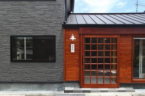 Akuneにあるお宿とととの木製のドアと窓のある建物