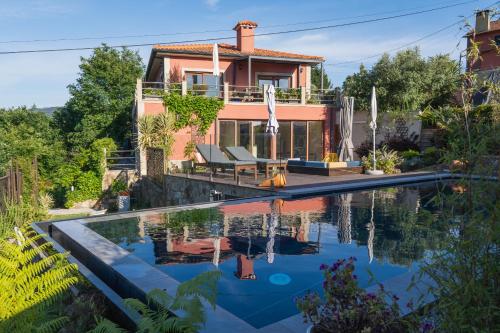 a house with a swimming pool in front of a house at Travessia do Sol - Eco Lodge and Retreat Centre in Gemieira