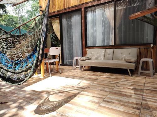 a hammock in a room with a couch and chairs at Cool Waters Jungle Villas in Uvita