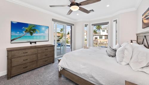 Un dormitorio con una cama y un televisor sobre una cómoda. en Blue Jasmine, en Marco Island