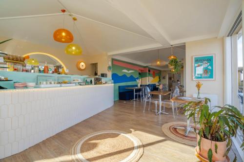 a restaurant with a counter and tables in a room at Hôtel Océan in Capbreton