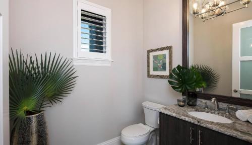 a bathroom with a sink and a toilet and a mirror at Addison Opulence in Marco Island