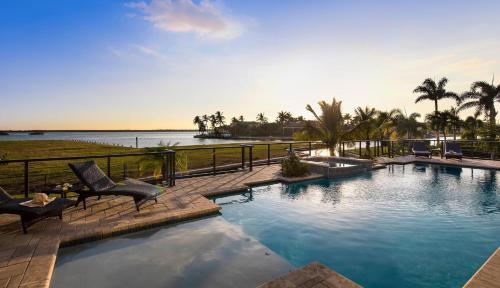 a swimming pool with chairs and a view of the water at Addison Opulence in Marco Island