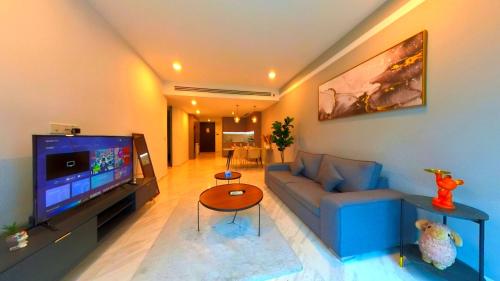a living room with a blue couch and a flat screen tv at Eaton Residence KLCC - KL SUITE in Kuala Lumpur