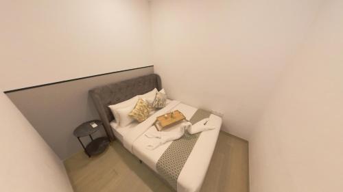 a white couch with pillows and a book on it at Eaton Residence KLCC - KL SUITE in Kuala Lumpur