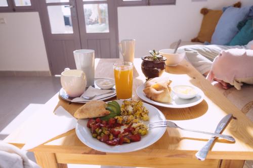 a wooden table with a plate of food and drinks at House Of Omm in Sidi Kaouki