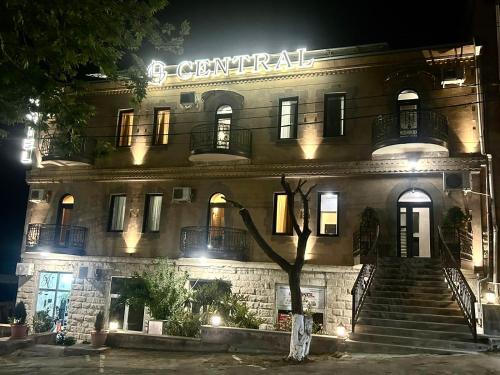 MeghriにあるCentral hotelの夜に屋根の上に看板が立っている建物