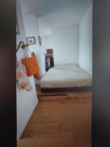 une chambre avec un lit dans une pièce blanche dans l'établissement le Regina, à Antibes