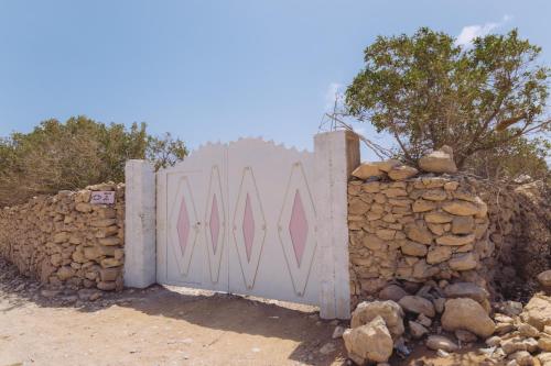 a gate in a stone wall with a stone wall at House Of Omm in Sidi Kaouki