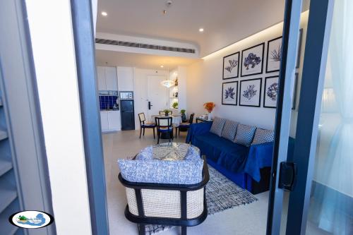 a living room with a blue couch and a table at Oscar Seaview Apartment in Phu Quoc