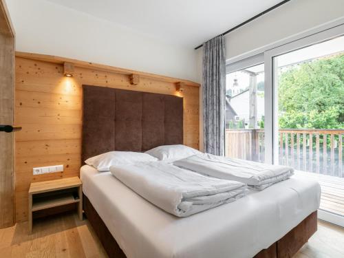 a bedroom with a large bed with a large window at Apart33 Top 1-30 in Haus im Ennstal