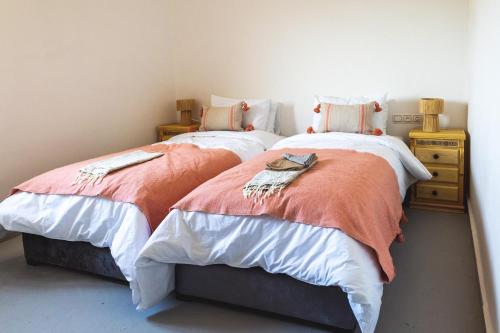 two beds sitting next to each other in a bedroom at House Of Omm in Sidi Kaouki