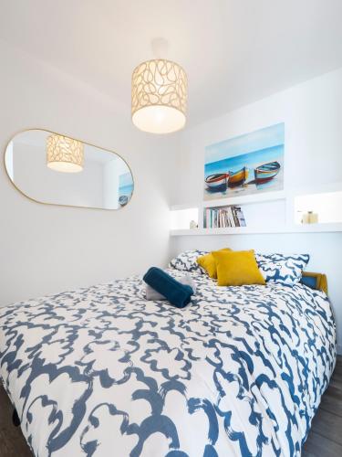 - une chambre dotée d'un lit bleu et blanc avec un oreiller jaune dans l'établissement Studio luxe vue panoramique baie La Baule, à La Baule