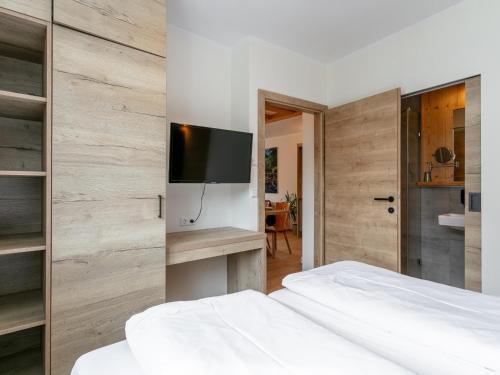 a bedroom with a white bed and a flat screen tv at Apart33 Top 1-30 in Haus im Ennstal