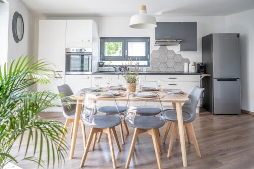 une cuisine et une salle à manger avec une table et des chaises en bois dans l'établissement Appartement l'Eden, à Horbourg-Wihr