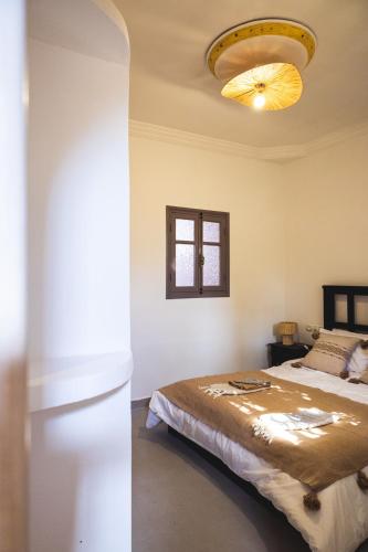 a bedroom with a bed and a chandelier at House Of Omm in Sidi Kaouki