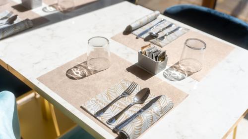 a table with wine glasses and utensils on it at Hotel Eden in Toscolano Maderno
