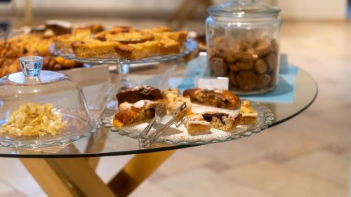 a glass table with pies and other desserts on it at Hotel Eden in Toscolano Maderno