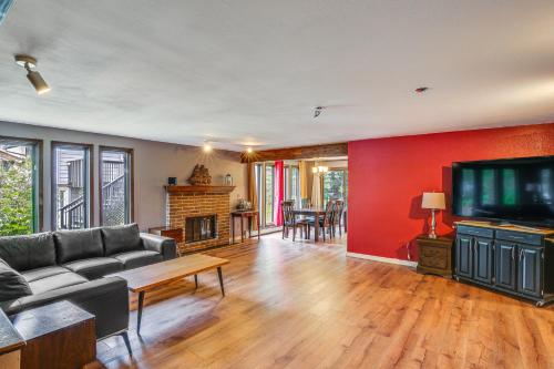 a living room with a couch and a flat screen tv at Near Downtown and Fishing Anchorage Escape! in Anchorage