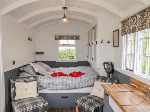 a small bedroom with a bed and two chairs at Lady Bird Retreat in Saltburn-by-the-Sea