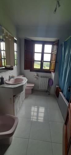a bathroom with two sinks and a toilet and a window at La Sierra del Aguanaz in Entrambasaguas